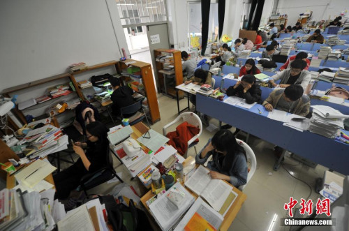资料图:2016年12月22日,福州一所大学校园内,考研专用教室里的桌面上堆满了学生们的各种复习资料。 张斌 摄 资料图:2016年12月22日,福州一所大学校园内,考研专用教室里的桌面上堆满了学生们的各种复习资料。 张斌 摄