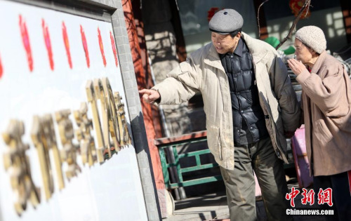 史先林陪患有老年痴呆的老伴散步,考她墙上的字。 <a target='_blank' href='http://www.chinanews.com/'>中新社</a>记者 杨可佳 摄 史先林陪患有老年痴呆的老伴散步,考她墙上的字。 <a target='_blank' href='http://www.chinanews.com/'>中新社</a>记者 杨可佳 摄