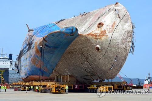 资料图片:2017年4月11日下午,在木浦新港,工作人员正将模块运输车抽离“世越”号船体。(韩联社) 资料图片:2017年4月11日下午,在木浦新港,工作人员正将模块运输车抽离“世越”号船体。(韩联社)