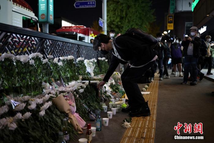 韩国民众在踩踏事故现场摆放鲜花悼念遇难者