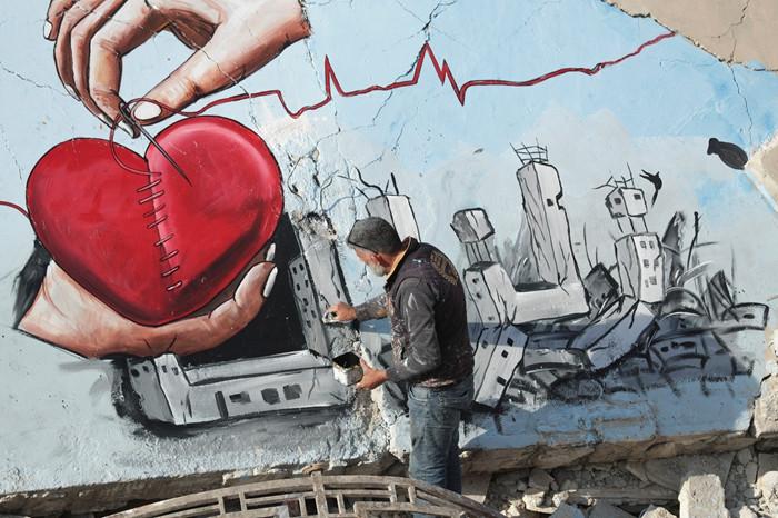 叙利亚艺术家在地震废墟上画画