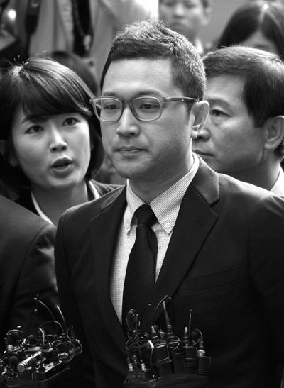 25日,韩国总统李明博长子李时炯(前)前往韩特别检察官小组所在地接受调查。新华社发