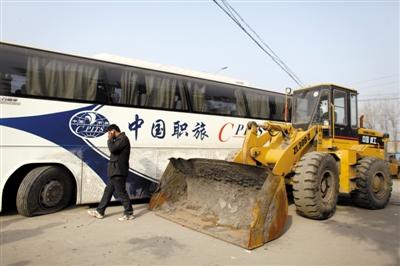 昨日,迪沟镇村民把自家的铲车开来,挡住被扣大巴车。新京报记者 侯少卿 摄
