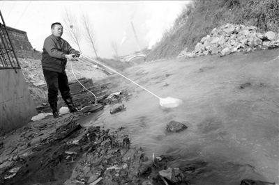 工作人员正在对水进行取样检验。本报记者徐晓帆摄