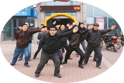 一月二十一日,在武汉东西湖区七雄路星光大道音乐会所门前,一群农民工摆“航母Style”造型、跳骑马舞讨薪。 杨涛摄