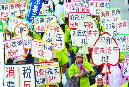 5月1日，大批民众在东京举行抗议集会。图为手举反对修改和平宪法标语牌的示威者。