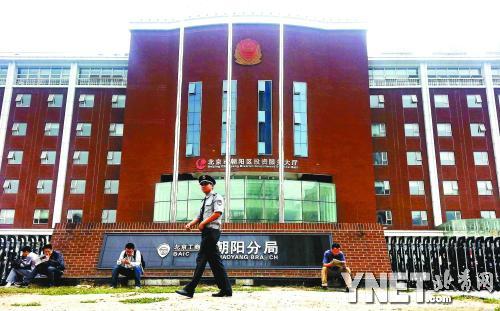 中午被“轰”出大厅的办事群众坐在路边干等 摄影/本报记者 崔峻