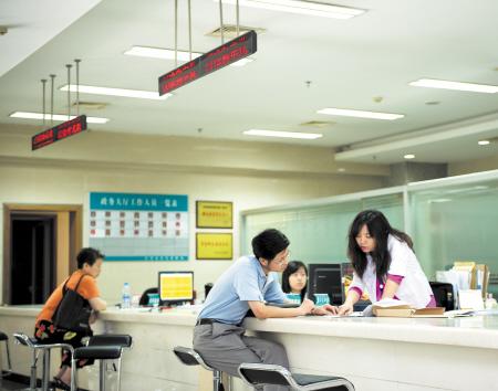 7月4日,在长沙市房产交易大楼,工作人员向经适房上市交易申请者讲解申报流程。邹麟 摄