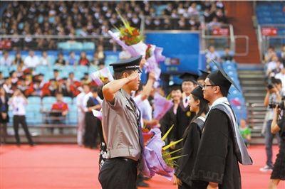 毕业生代表为学校教师、教务人员、保安送花致谢,一名保安回礼。京华时报记者 王海欣 摄