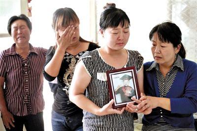 南尚乐村,硕硕的母亲捧着儿子生前的照片。