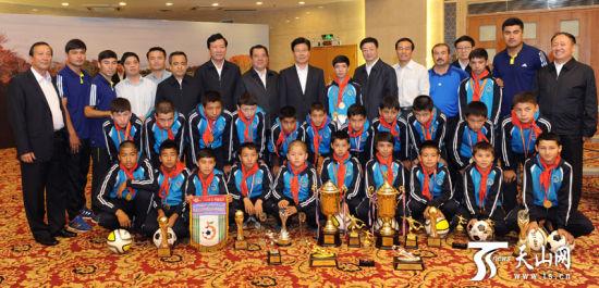 张春贤等领导与少年足球运动员代表一起合影。新疆日报记者卢民一摄