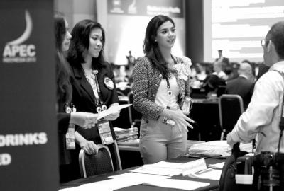 昨天,在APEC峰会媒体中心,工作人员与记者交谈。据悉,前来采访的各国媒体记者超过3000人。 新华社发