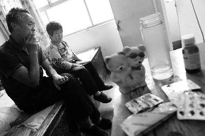 王坤亮和妻子提到多年来儿子的不孝,沉默良久。桌子上摆放着刚刚从医院拿回来的药 摄/法制晚报记者 刘畅