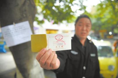小区工作人员展示停车发票,证明该小区门口停车可以收费。