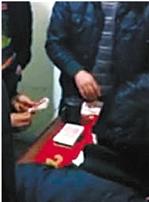 视频截图,可以很清楚地看到牌桌上摆着厚厚的百元钞票。