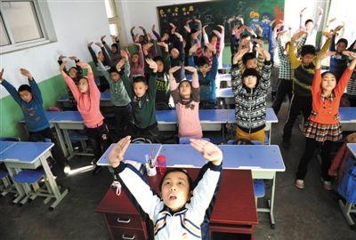 12月11日,学生在教室内演示“防霾”武术健身操。全国各地遭受雾霾笼罩,石家庄光明路小学为此发明了一套“防霾”武术健身操。图/CFP