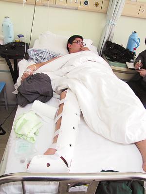 摔断腿的小冯躺在病床上.