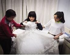 病房里,按捺不住激动之情的冯莹拿起婚纱比了又比。