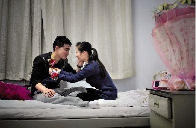 3月1日晚8点半,心情激动的冯莹、杨海斌在病房试戴写有“新娘”、“新郎”的鲜花牌。