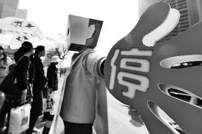 上午在大望路路口,志愿者的“大手”写着“停”字,倡导行人不闯红灯 摄/法制晚报记者 洪煜