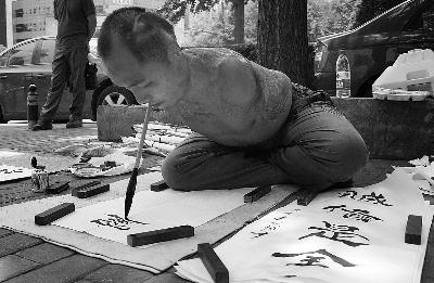 无臂青年以口代手街头卖字称想上中央美院图