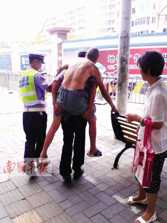 老汉过马路时突然疾病 交警将其背至安全地带(图)