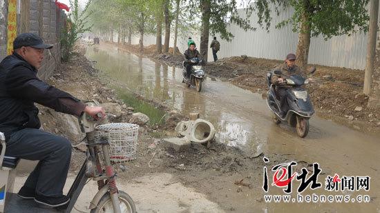 丽锦园小区门口道路上污水流淌,不仅恶臭熏天,而且严重影响居民出行。