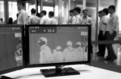 6月9日,韩国首尔的一座大楼内,红外热像仪检测人们的体温。图/CFP