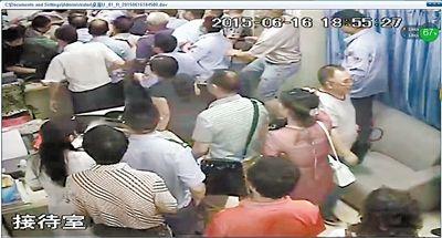 6月16日18点56分:死者家属站上办公桌,打翻了电脑。监控截图