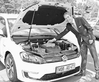 德国政府2009年制定《国家电动汽车发展计划》,目标是到2020年让100万辆电动汽车上路,并使德国成为全球领先的电动汽车市场和制造基地。图为工作人员向记者介绍高尔夫电动汽车。