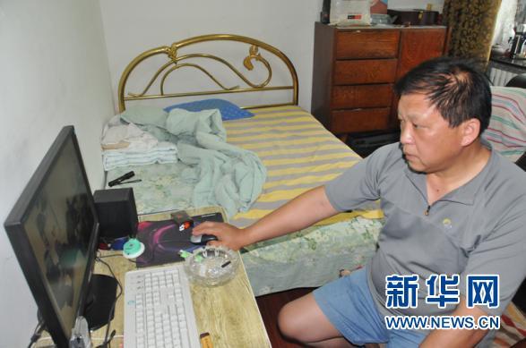 王克成在翻看父亲的旧照片.