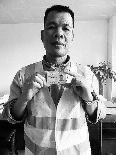 老家广西横县的环卫工陈彬荣手持广州市花都区的居民身份证,今年,他