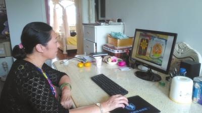 李征琴在家中查看照片。京华时报记者张淑玲摄