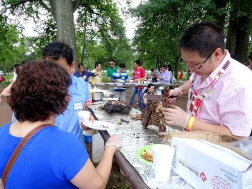新州六华人社团在高地公园举办户外烧烤社团联谊会，现场的烧烤美食吸引与会者排队领取。(美国《世界日报》/谢哲澍