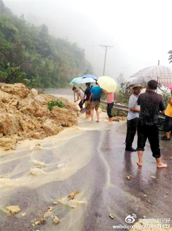 重庆暴雨冲断路基男生徒手挪500斤石头疏通道路(图)