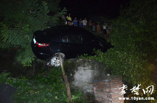 湖北一女司机驾车飞下山坠落半山腰被大树卡住(图)