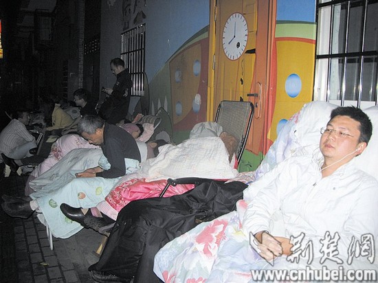 幼儿园招生家长雨夜通宵排队报名摆躺椅裹棉被