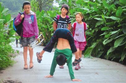 10岁患病男童倒立爬行上学立志好好读书报答奶奶
