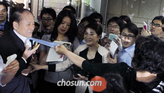 李明博胞兄涉受贿被捕遭受害者扔鸡蛋泼水(图)