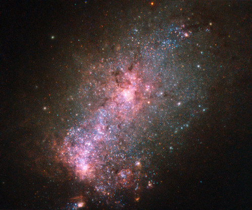 NASA拍摄“星暴星系”:玫瑰色核心孕育年轻恒星