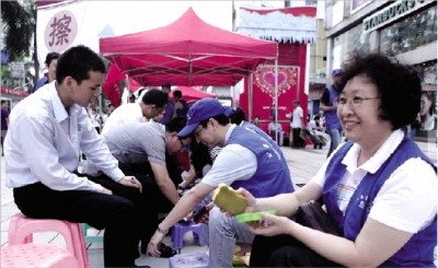 深圳公务员街头擦鞋被指作秀志愿者称出自真心