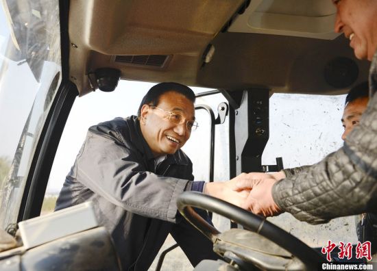 李克强查看农田深松情况登上驾驶室与农机手交谈