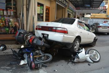 大马华人老妇开车慌张连发车祸压住3辆摩托(图)