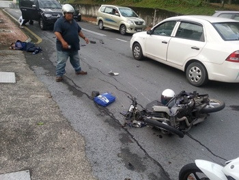 马来西亚一名骑摩托车的华裔青年被失控冲过逆向路的轿车撞倒﹐头部受