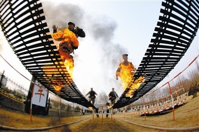 南京军区某旅战士通过带有火障的晃动横梯(图)