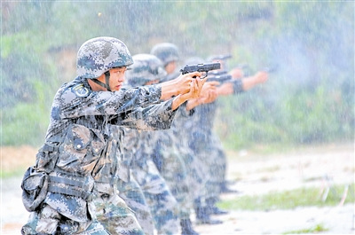 南京军区某团官兵冒雨参加手枪速射考核(图)