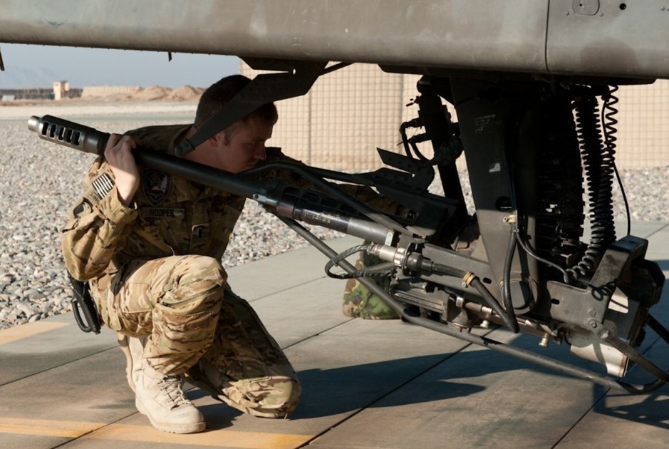 团第1营地勤人员正在为ah-64d阿帕奇攻击直升机装填30毫米机炮用弹药