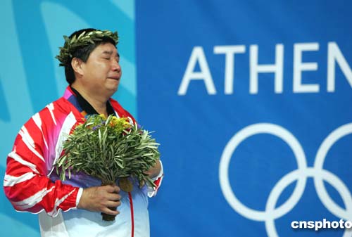 十四岁的中国"老枪"王义夫在雅典奥运会男子十米气手枪比赛中获得冠军