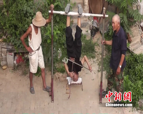 河南81岁退休教师倒挂空中演奏二胡图