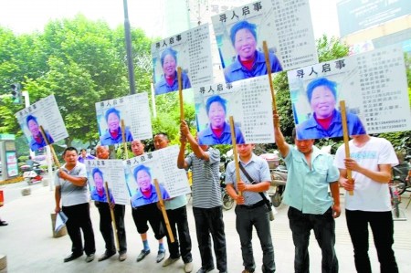 母亲走失儿子率众人天天举牌沿街寻母(图)